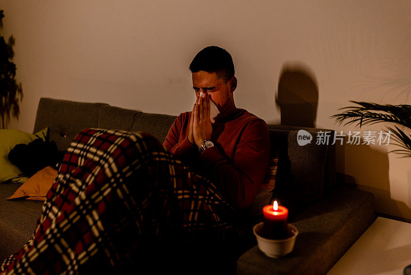 在一次电力危机中，一个患流感的年轻人正在测量体温。
