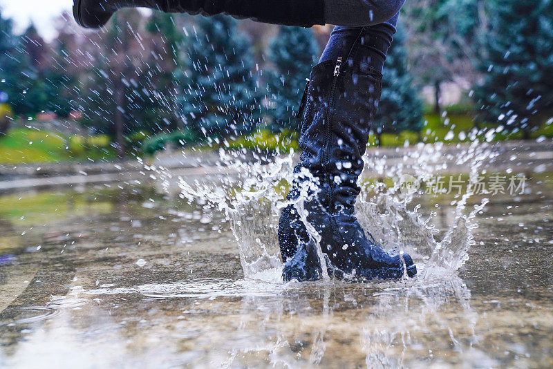 穿着雨靴在深水坑里跳