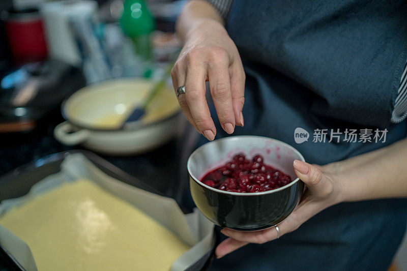 年轻女子在厨房做饭。樱桃饼