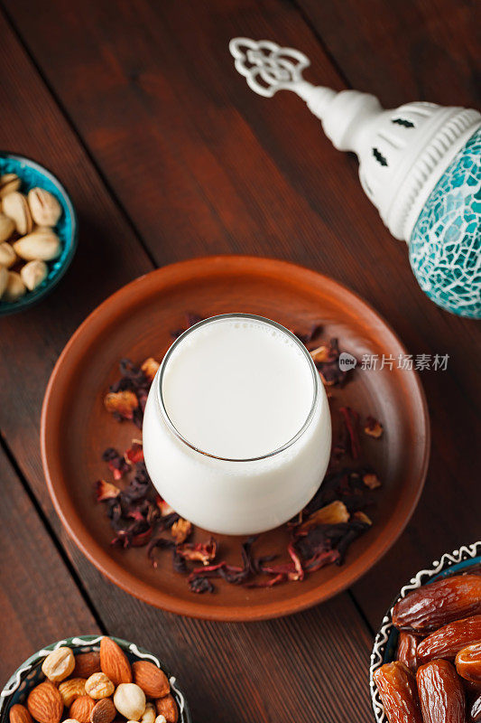 斋月和开斋的穆斯林食物。把枣核、坚果和牛奶放在木板上。传统的开斋食物