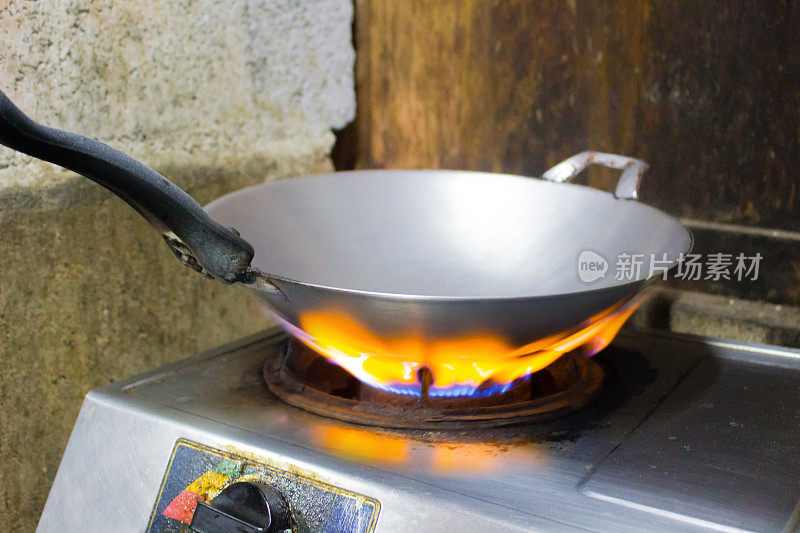 煤气炉上的锅正在加热，准备煎或炒。