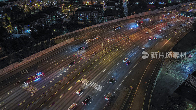 通往夜晚首都核心的发光道路:有汽车交通的照明高速公路。亚特兰大的夜生活。鸟瞰图。长时间曝光，车灯痕迹