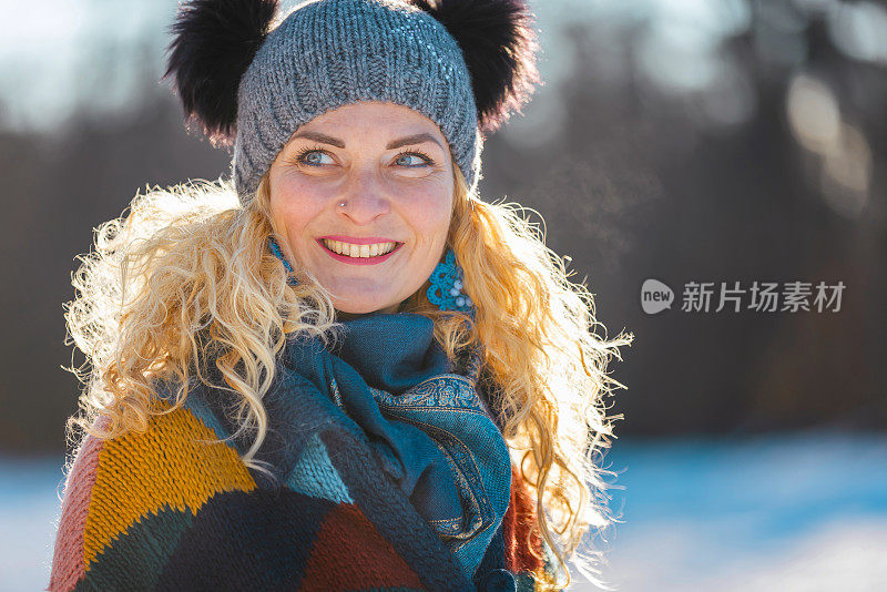 幸福的女人在冬天森林附近的白雪皑皑的草地