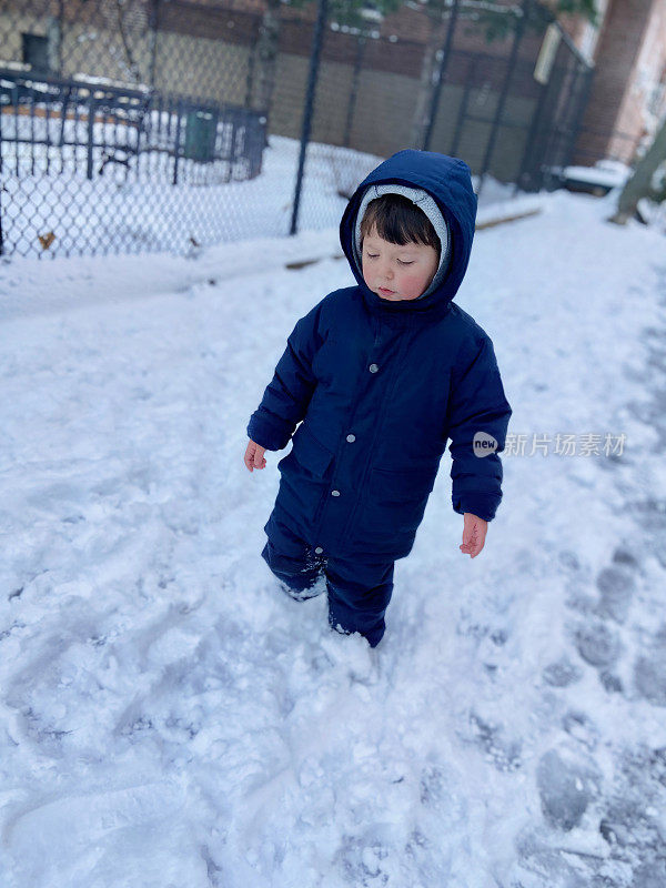 一个男孩站在公园的雪地里