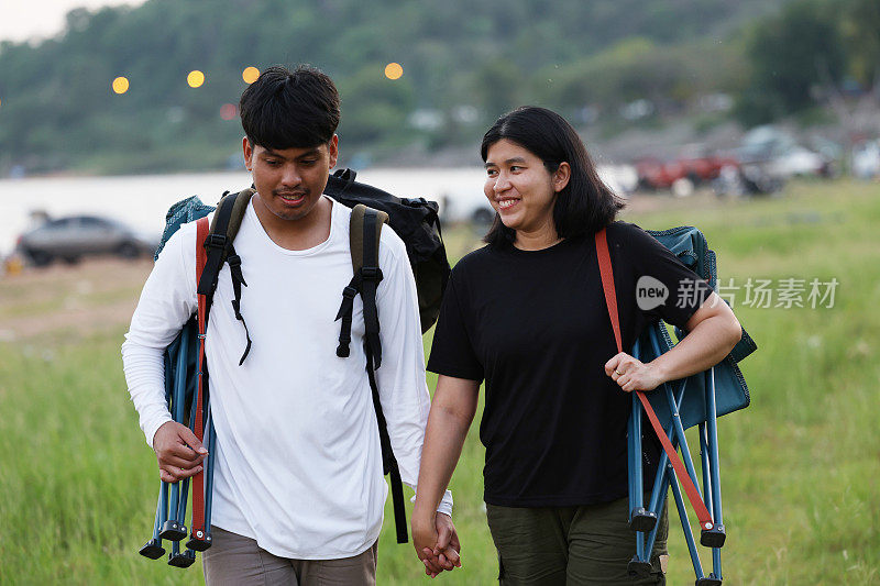 一对徒步旅行者在森林小径上。男男女女徒步旅行者在山上徒步旅行。一对年轻夫妇背着背包在森林里散步。