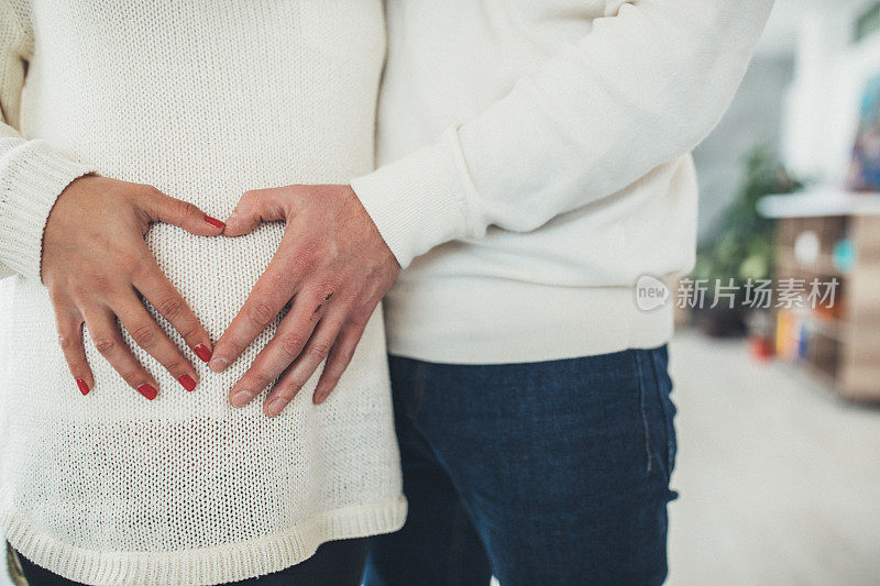 父母的手触摸孕妇的肚子