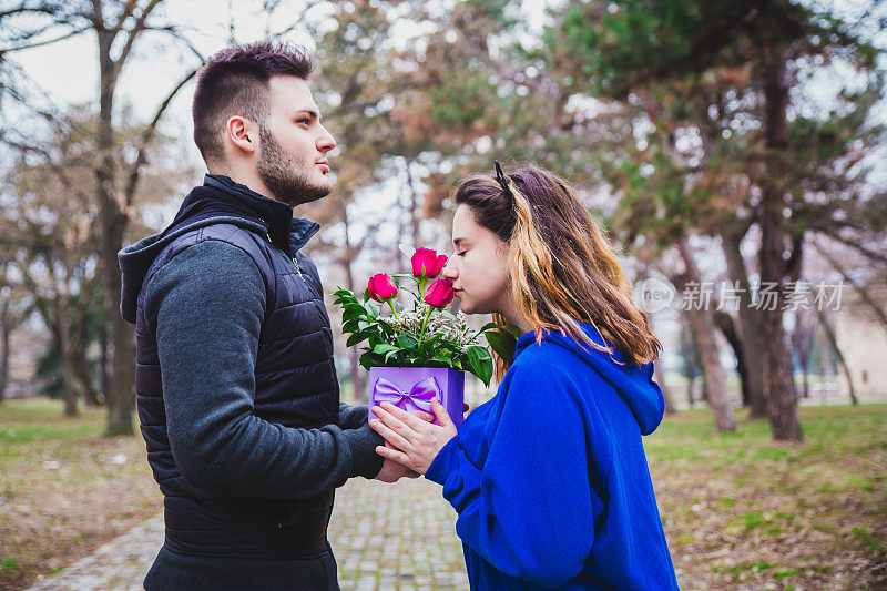 一对年轻夫妇带着礼物在公园里