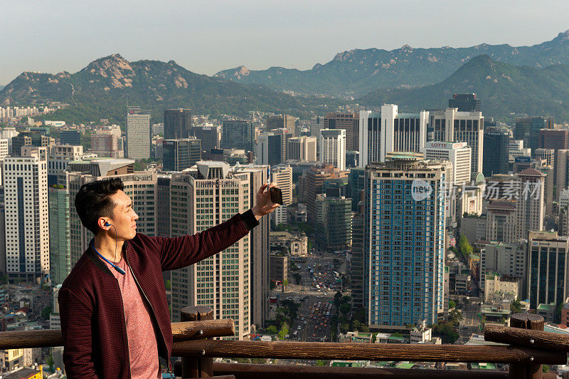 一名男子在与首尔的城市景观自拍