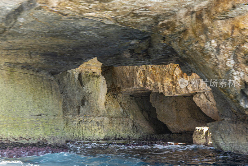 在地中海马耳他的海岸线上的蓝色洞穴旁边的海洞和岩层的观点。