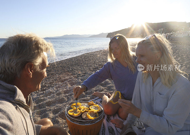 家人享受海滩烧烤日落