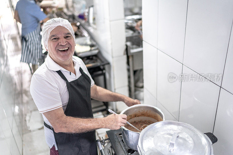 一个厨师在餐厅的工业厨房里煮豆子的肖像