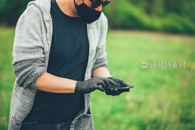 戴着口罩用手机的男子