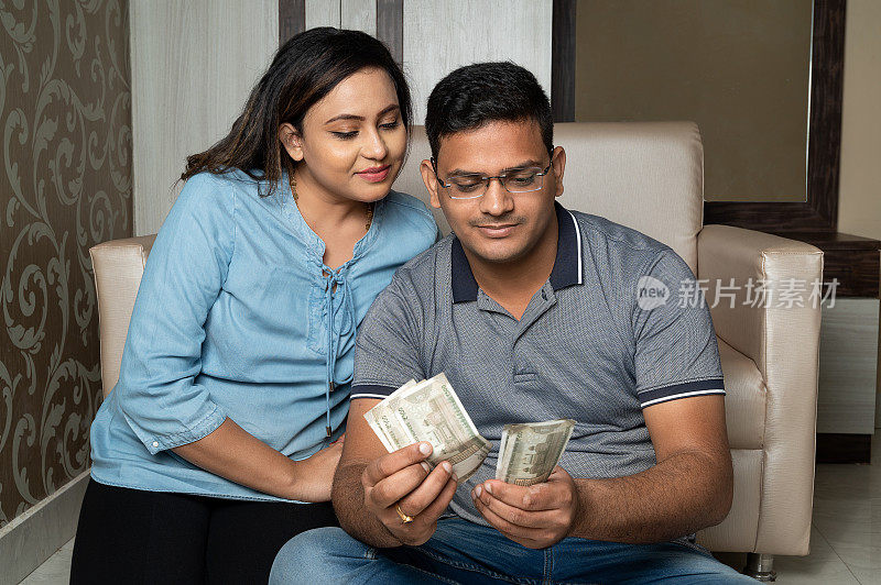 印度夫妇持有钞票或数钱。