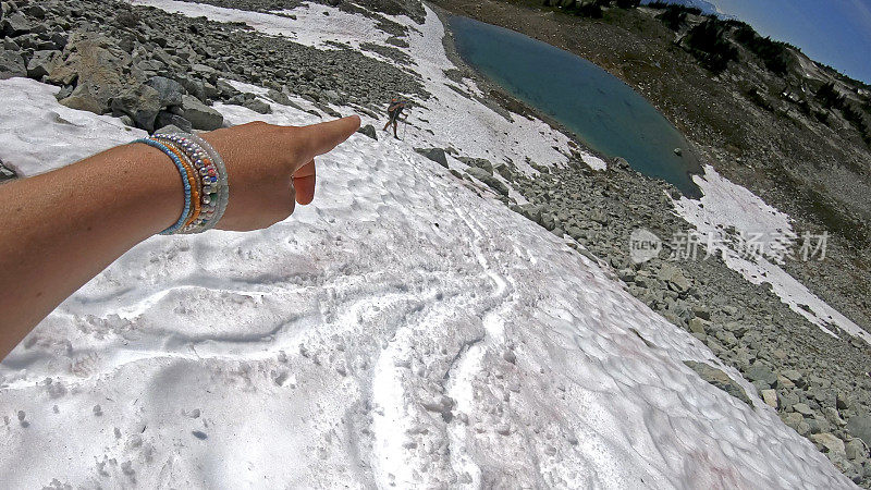 徒步旅行者沿着积雪的山坡跑下去