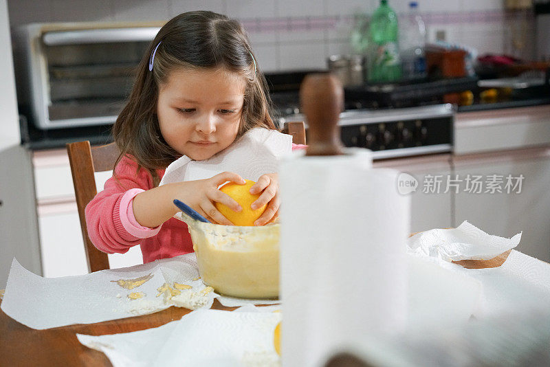 美丽的小女孩在隔离期间烹饪时使用柠檬