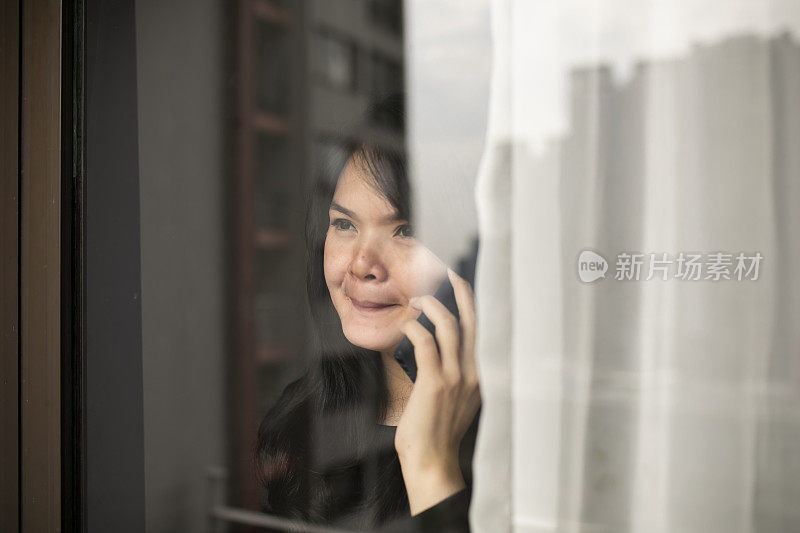 一个中国女人在她的公寓里使用电话