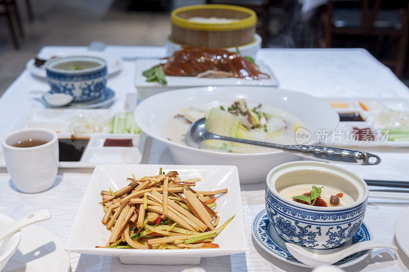 餐馆里美味的北京烤鸭、蔬菜汤、水果酸奶和炸干豆腐的特写
