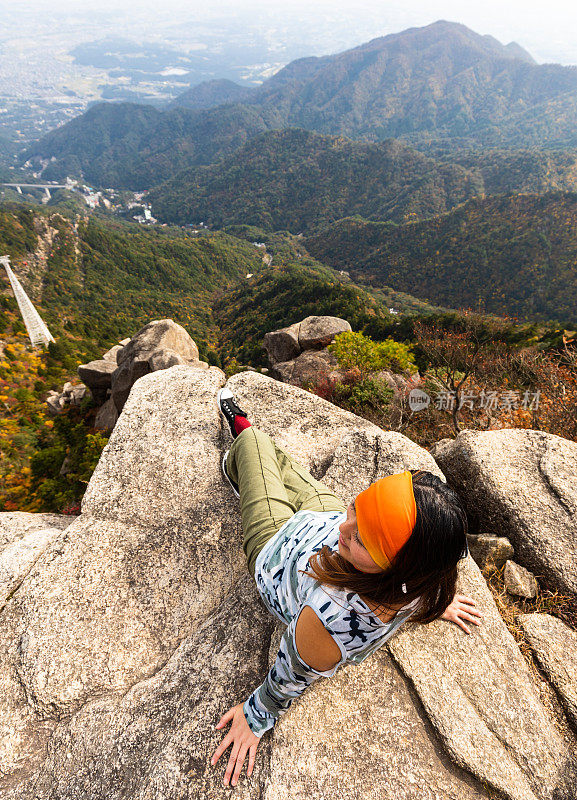 一名妇女坐在戈扎修秋山的悬崖峭壁上