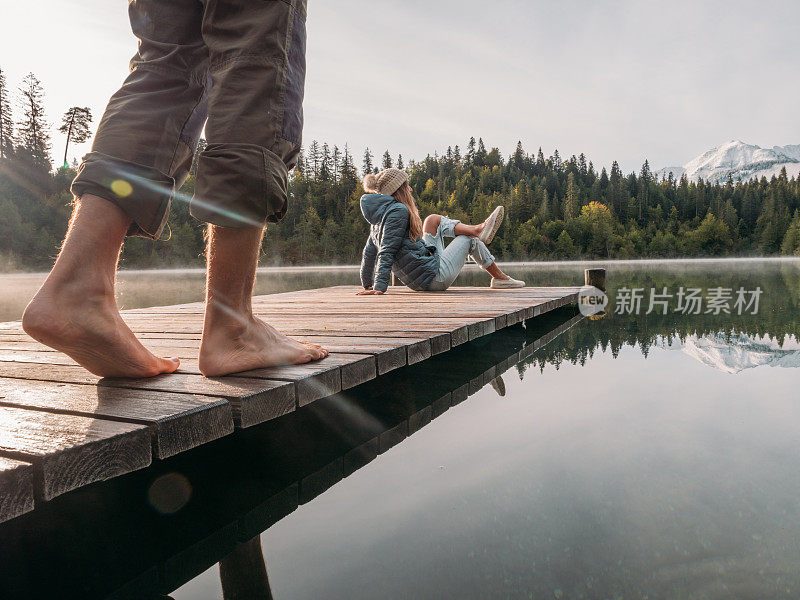 一对夫妇在早晨沿着木码头散步