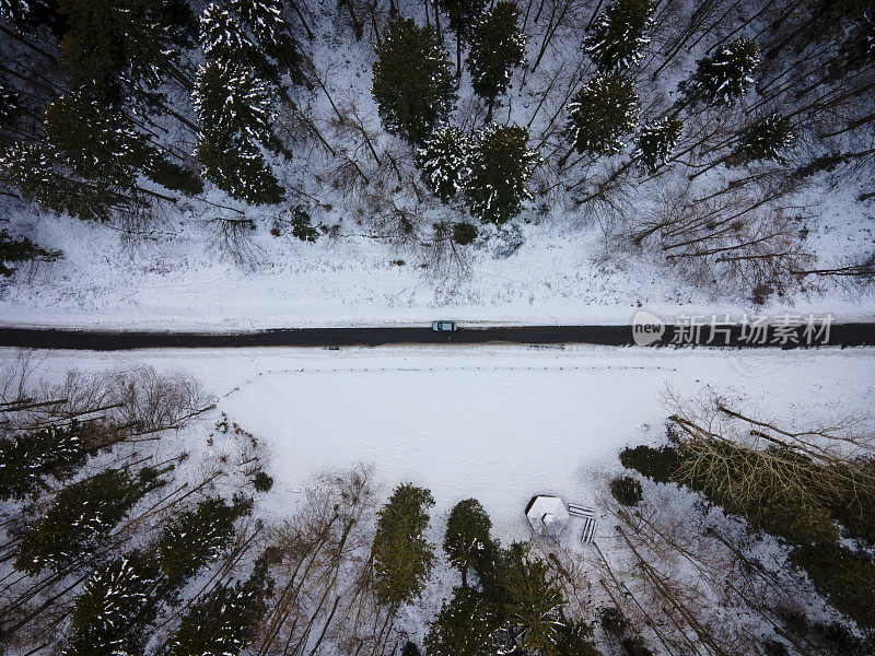 鸟瞰图上的一辆车在乡村道路在下雪的冬天