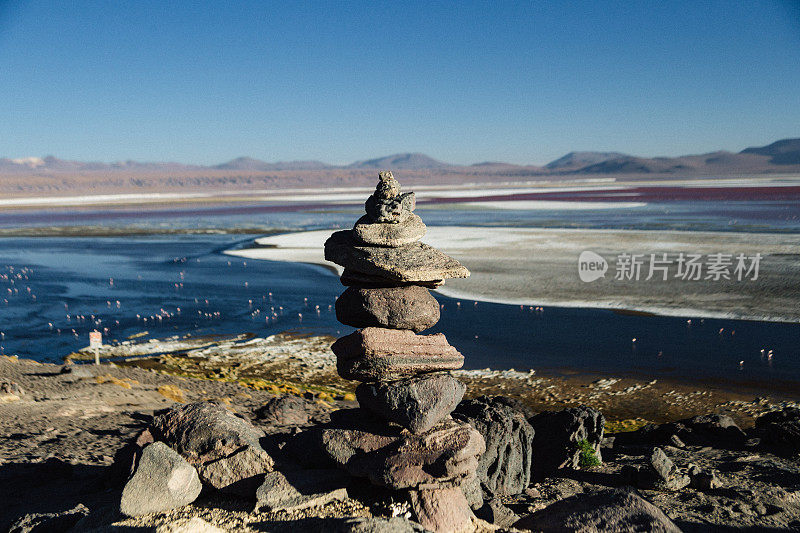 一个石头金字塔在拉古纳科罗拉多的背景在Altiplano，玻利维亚日落