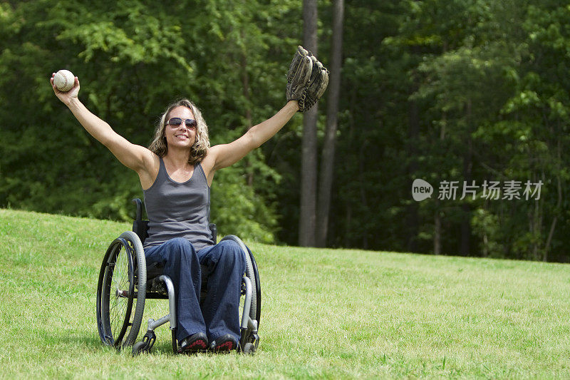 坐轮椅的女人在绿地上玩接球