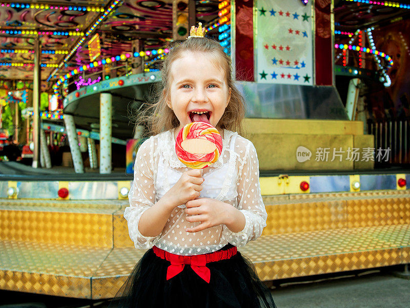 可爱的小女孩在游乐场拿着棒棒糖