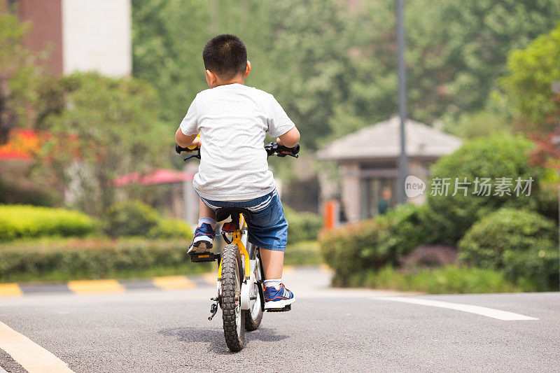 小学生在一个安静的小区里骑自行车