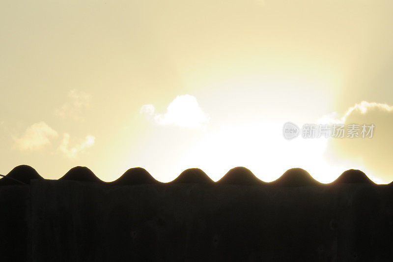 夕阳背景下的波纹屋顶