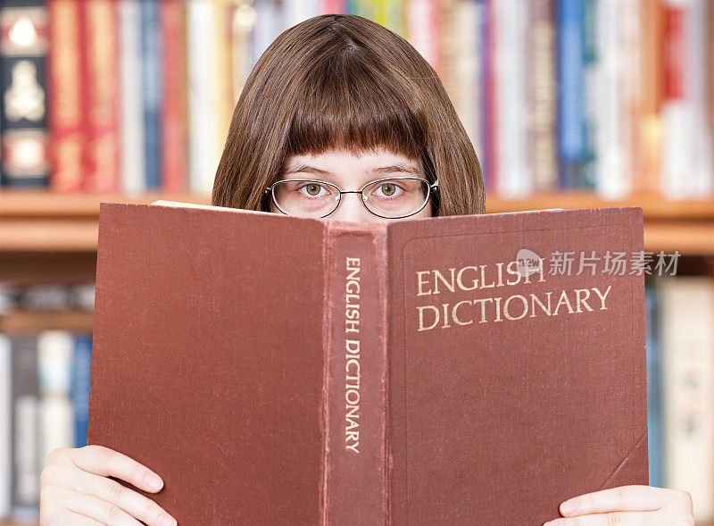 这个女孩在看英语词典和书
