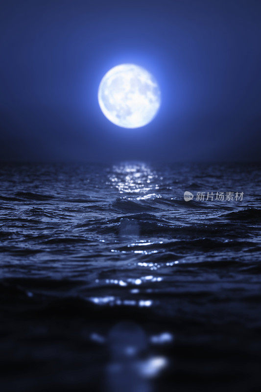 一轮满月升起在空旷的海面上