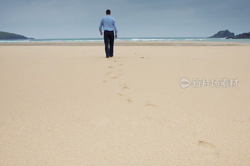 一个人走在荒芜的海滩上