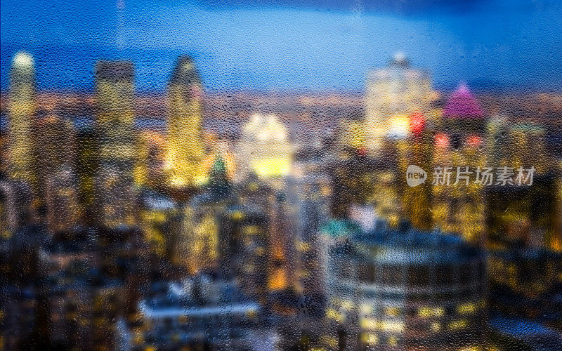 雨滴落在窗户上，背景是散焦的建筑物