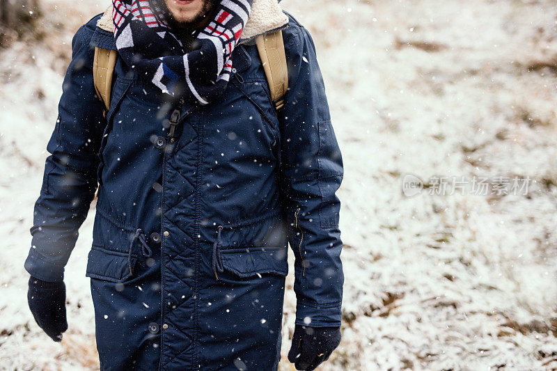 穿着冬装站在雪地里的冒险家