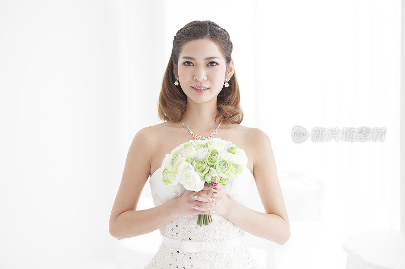 一个新娘与绿色花束的特写。