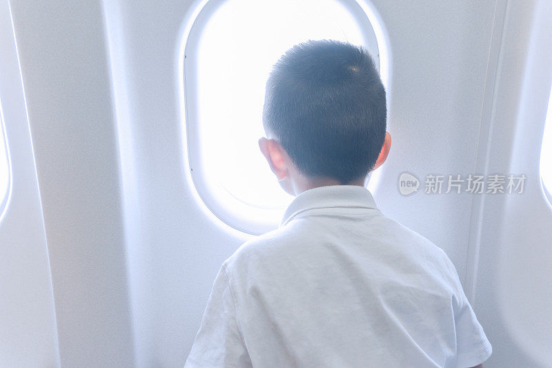 小男孩从飞机窗户往外看