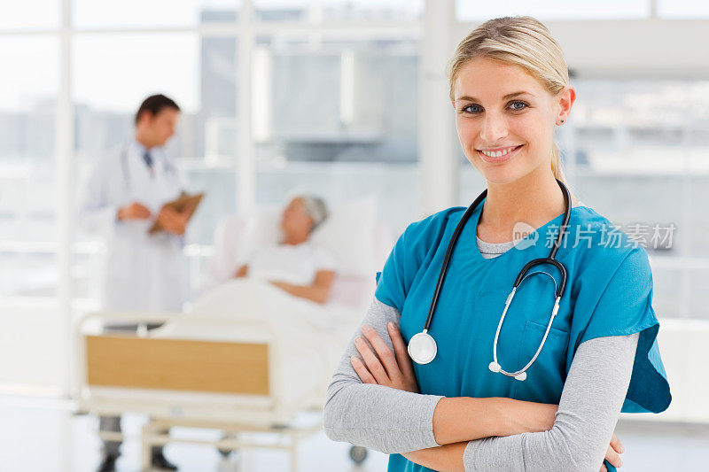 微笑的女医生，背景是同事和病人