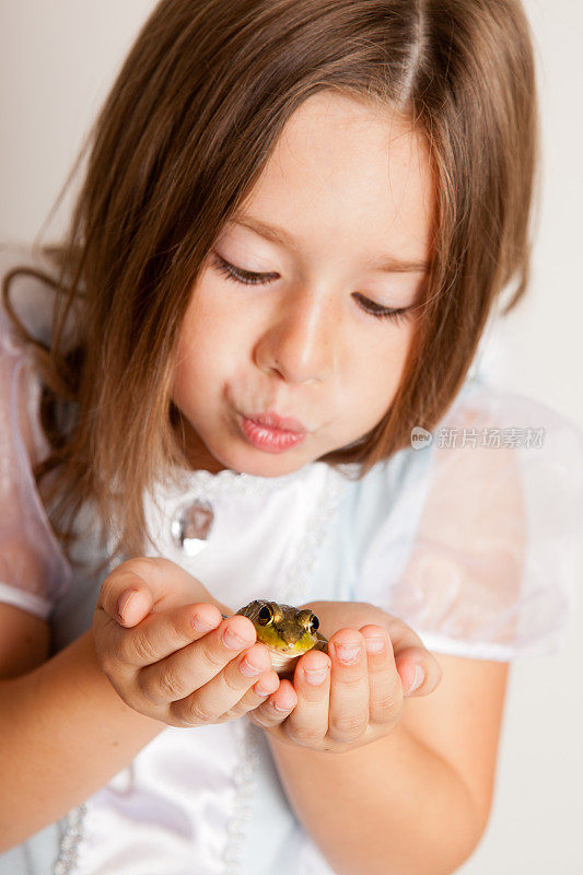 小公主俯身亲吻青蛙的彩色图像
