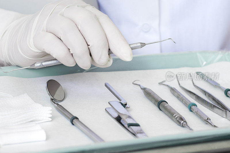 牙医用戴手套的手挑选牙科工具