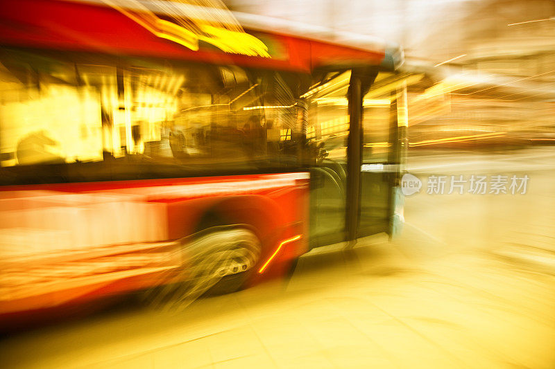 城市巴士在阳光下行驶在街道上，模糊的运动