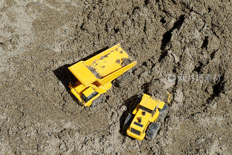 玩具建筑车辆在沙堆里