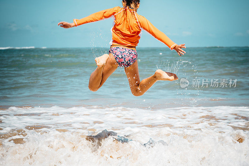 十几岁的女孩跳过海浪跳进海里