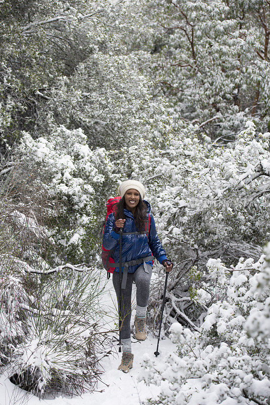 女人在下雪的天气徒步旅行。