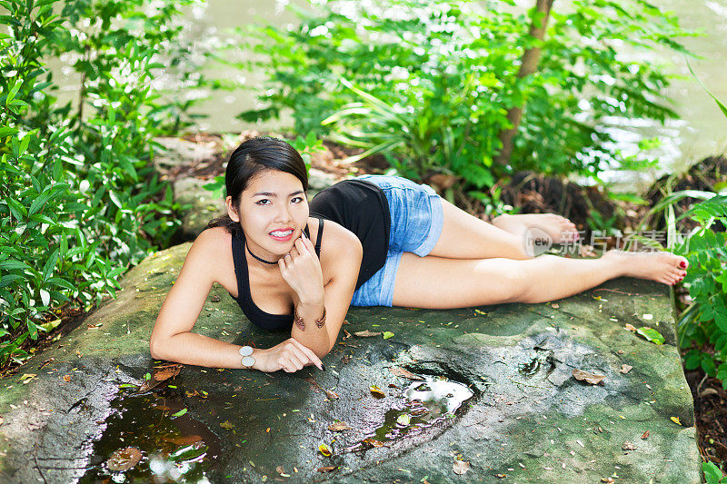 小泰国女孩躺在石头上