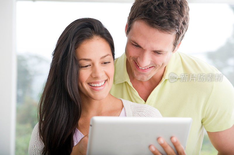 一对幸福的情侣在用平板电脑