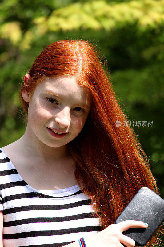 阳光下的女孩梳着她长长的红头发