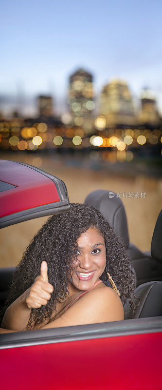 美丽的巴西女人驾驶敞篷车黎明在城市