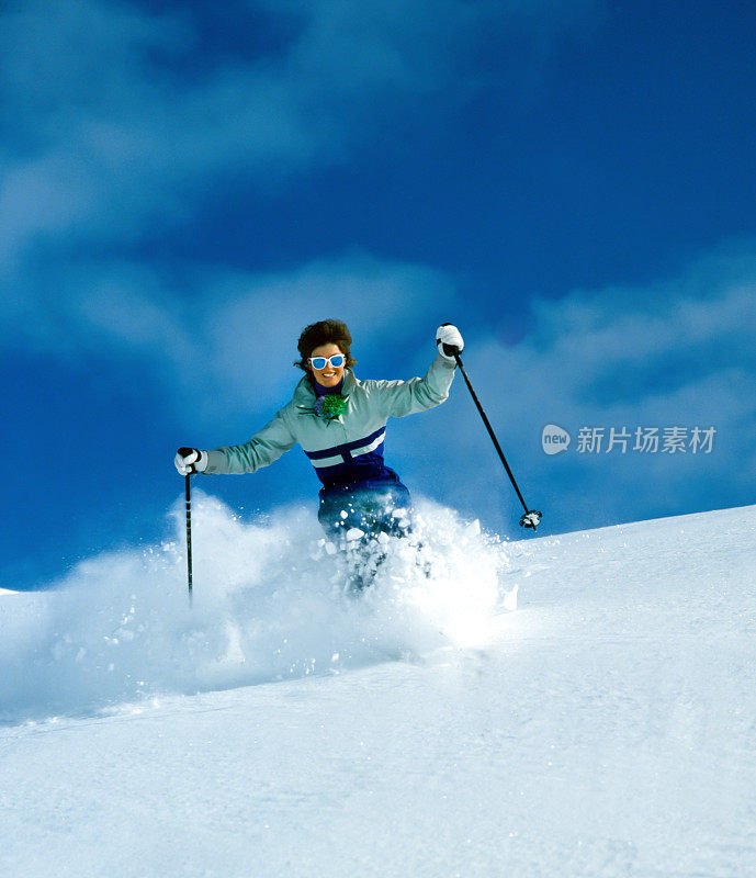 女子滑雪者在膝盖深粉雪，新西兰