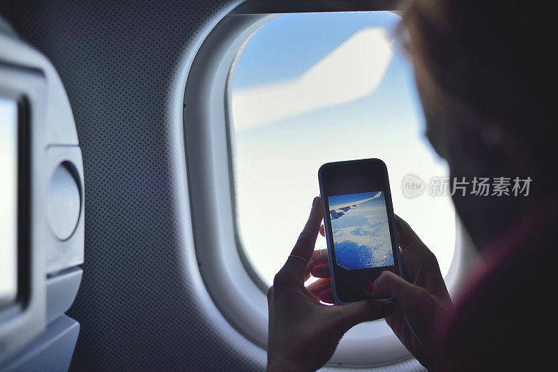 一名年轻女子在飞机上拍照
