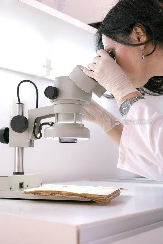 一个女技术员在她的显微镜下